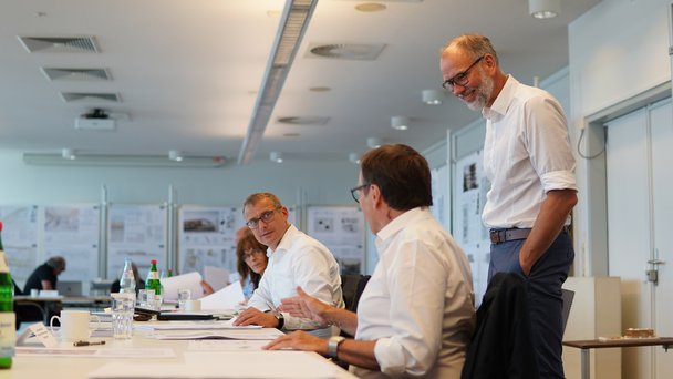 Menschen sitzen am Tisch und unterhalten sich