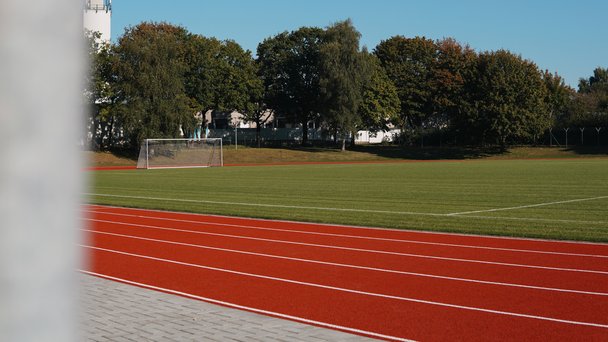 Blick auf eine Laufbahn und ein Feld mit Fußballtor.