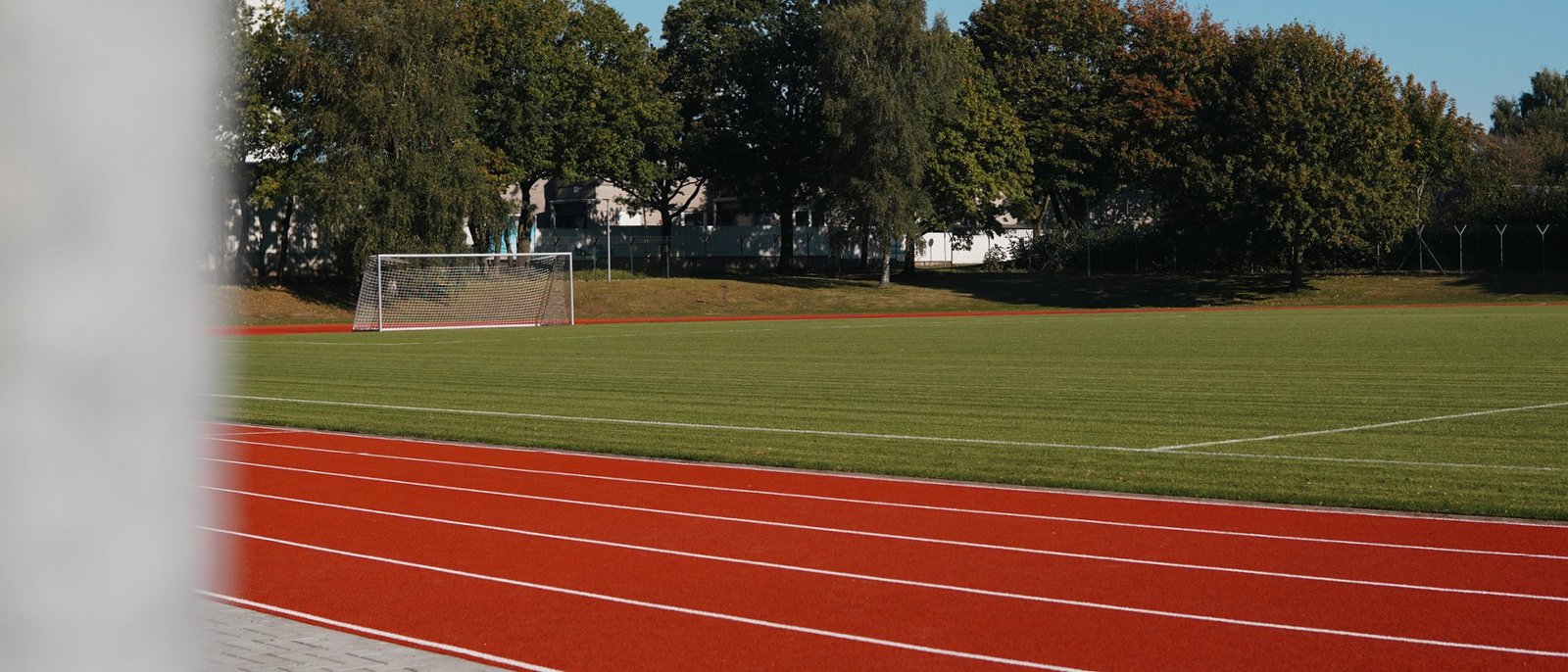 Blick auf eine Laufbahn und ein Feld mit Fußballtor.