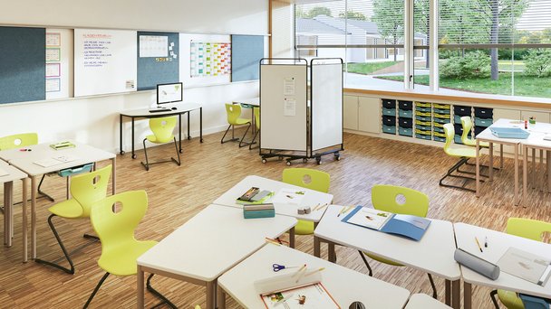 Ein Klassenzimmer mit grünen Stühlen und weißen Tischen.