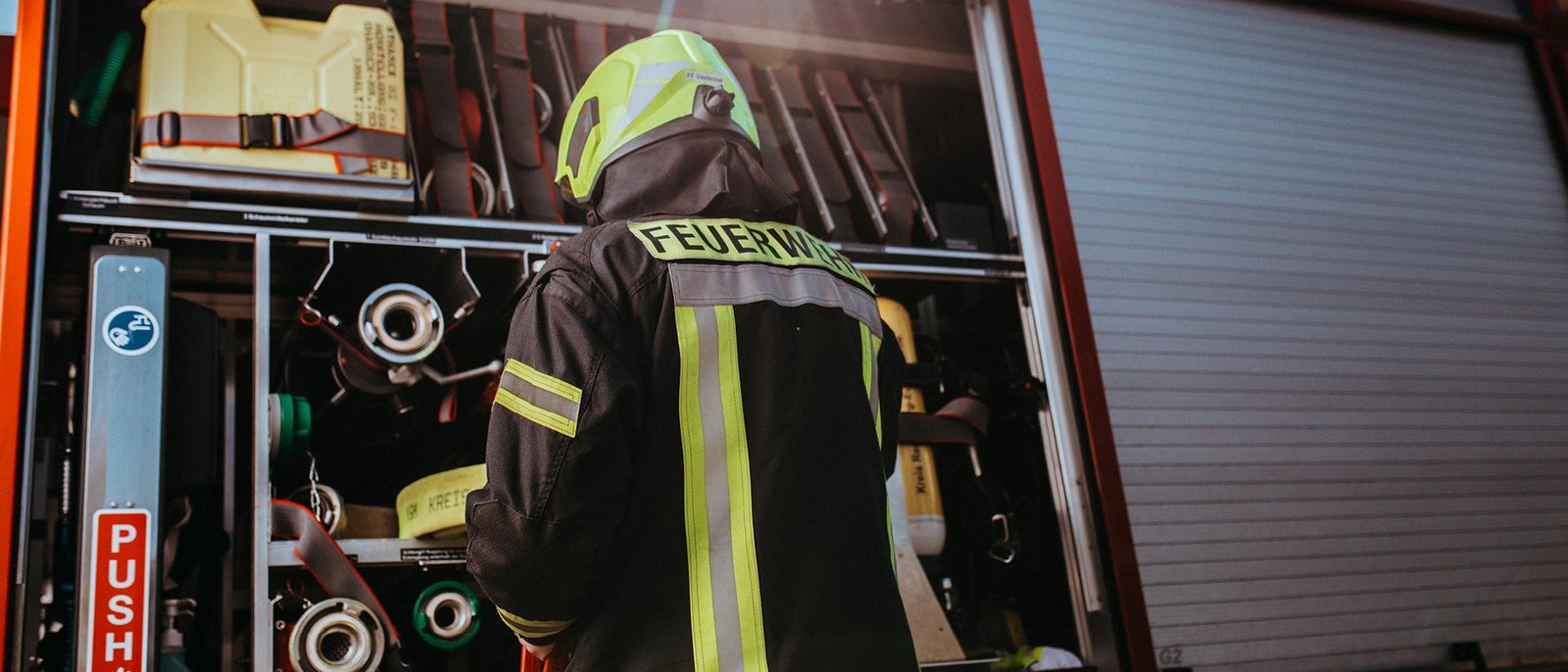 Ein Feuerwehrmann steht vor dem Einsatzfahrzeug