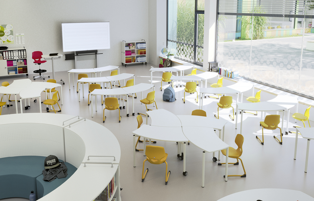 Blick in einen Klassenraum mit runden Tischen und gelben Stühlen.